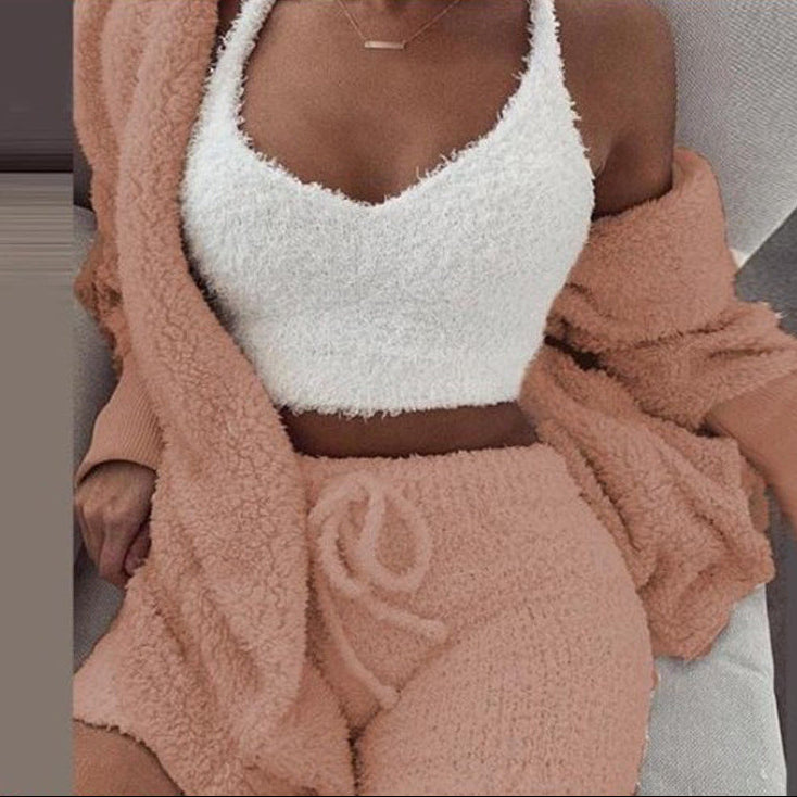 Person wearing a white fuzzy top and pink fuzzy pants with a matching coat.