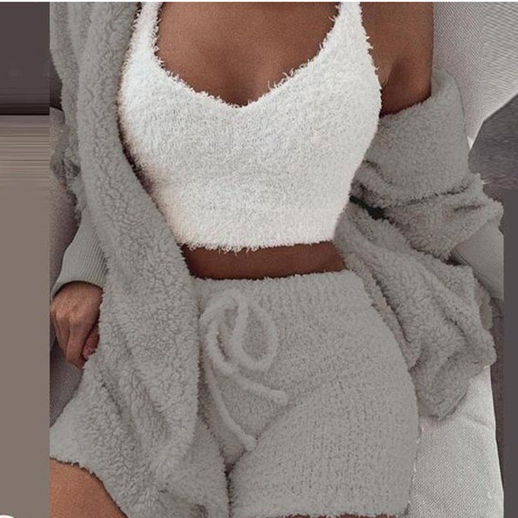 Person wearing a white fuzzy top and gray shorts with a matching robe.